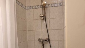 A shower with a handheld showerhead and a fixed showerhead, tiled walls, and a curtain. - Résidence hôtelière ERASMUS (Malakoff)