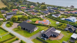 Luchtbeeld van een kustgebied met woonhuizen, wegen en een wateroppervlak.