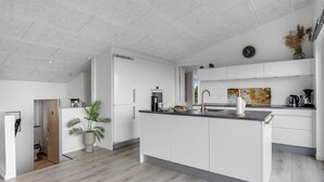 Een moderne keuken met witte kasten, een centraal eiland en een houten vloer.