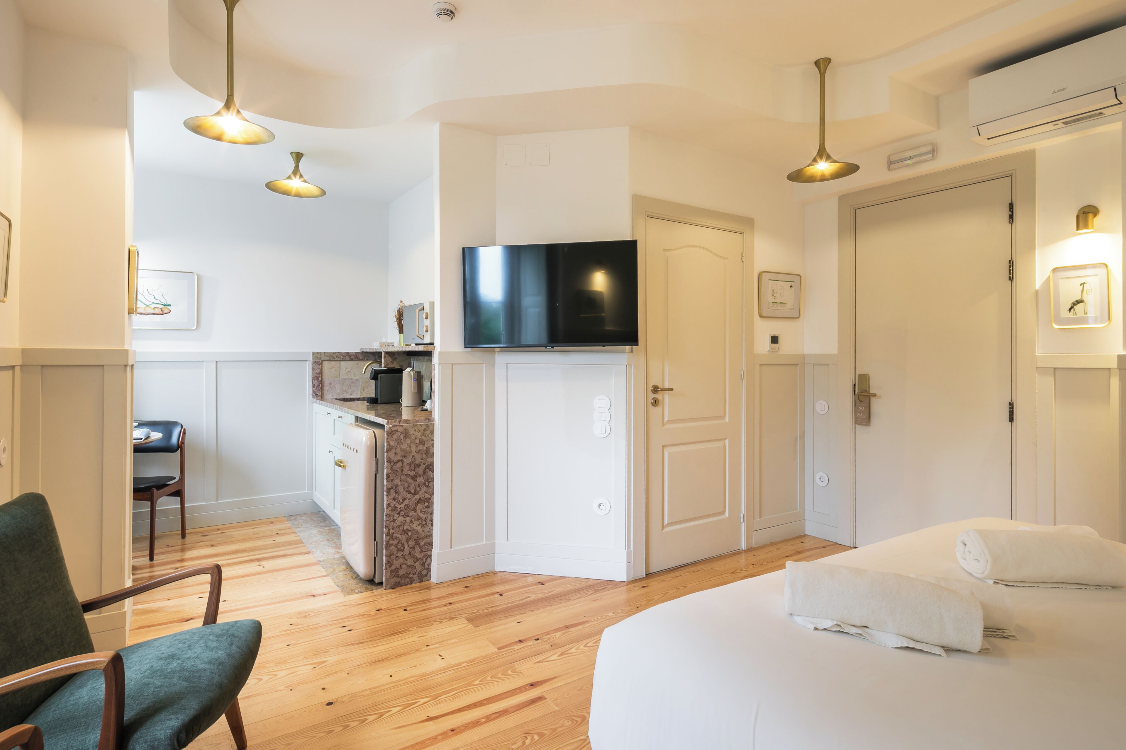 Una habitación de hotel con cama, televisor, escritorio y una silla.