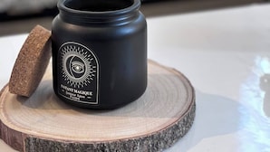 A black jar with a white label on a wooden coaster. - Charming apartment in Arras for a cozy getaway (Arras)