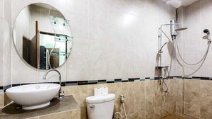 Un baño con un espejo redondo, un lavabo, un inodoro y una ducha.