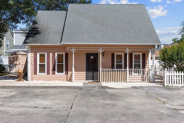 A single-story house with a front porch, a garage, and a small front yard.