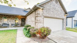 A two-story house with a stone facade, a garage, and a front porch with outdoor seating.