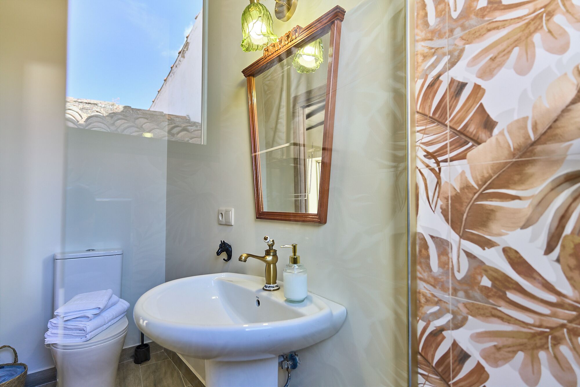 A bathroom with a white sink, a mirror, and a toilet.