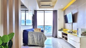 Una sala de estar moderna con un televisor grande, un sofá y un comedor.