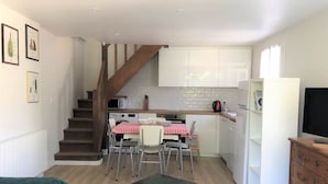 A compact living space with a kitchen, dining area, and a staircase.