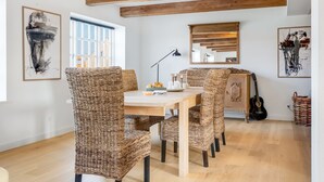 A dining area with wicker chairs, a wooden table, and a guitar. - "Albine" - 150m from the sea by Interhome (Skagen)