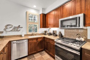 A kitchen with wooden cabinets, stainless steel appliances, a built-in microwave, and a dishwasher.
