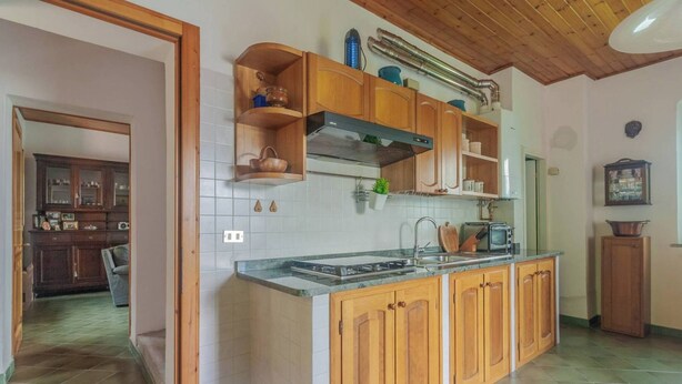 A kitchen with wooden cabinets, a built-in stove, and a microwave. - Varenna Wonders  (Varenna)