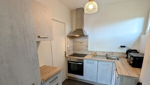 Una cocina moderna con horno empotrado, pileta de acero inoxidable y encimera de madera.