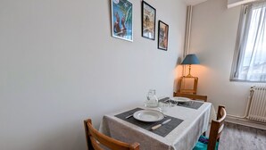 Un comedor con una mesa dispuesta para dos, una lámpara y un radiador.