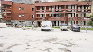 A multi-story building with a wooden facade, a stone base, and a sign indicating 'Bourg St. Maurice Centre Ville.'