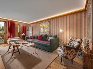 A cozy living room with a green sofa, patterned armchair, and a coffee table.