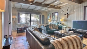 A spacious living room with a large leather sofa, a television, and a fireplace. - Spacious chalet with terrace and jacuzzi, near slopes for 14 people (La Plagne 1800)