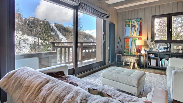 A cozy living room with a large window overlooking a snowy mountain. - Spacious chalet with terrace and jacuzzi, near slopes for 14 people (La Plagne 1800)