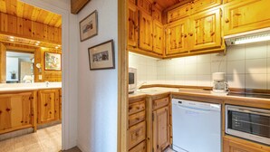 A kitchen with wooden cabinets, a dishwasher, and a coffee maker.