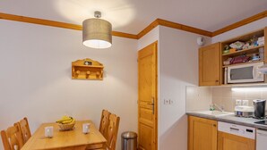 Pieni, käytännöllinen keittiö, jossa on puukehikot, mikroaaltouuni ja pesuallas.