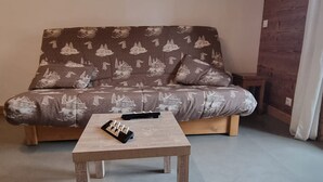 A living room with a sofa and a coffee table. - Cozy apartment in Les Gets, 4 pers, with parking (Les Gets)