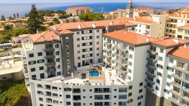 A high-rise building with multiple balconies and a rooftop pool. - Sun Flower with Oceanview (Caniço)
