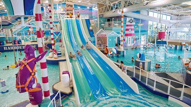 A large indoor water park with multiple slides, pools, and a lifeguard station. - Lodge - Sleeps up to 6, pet Friendly & bbq Allowed (Pwllheli)