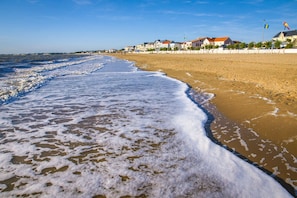 A beach with waves, a sandy shore, and houses in the background. - 3-star vacation rental, 300 meters from the beach, large private pool (Châtelaillon-Plage)