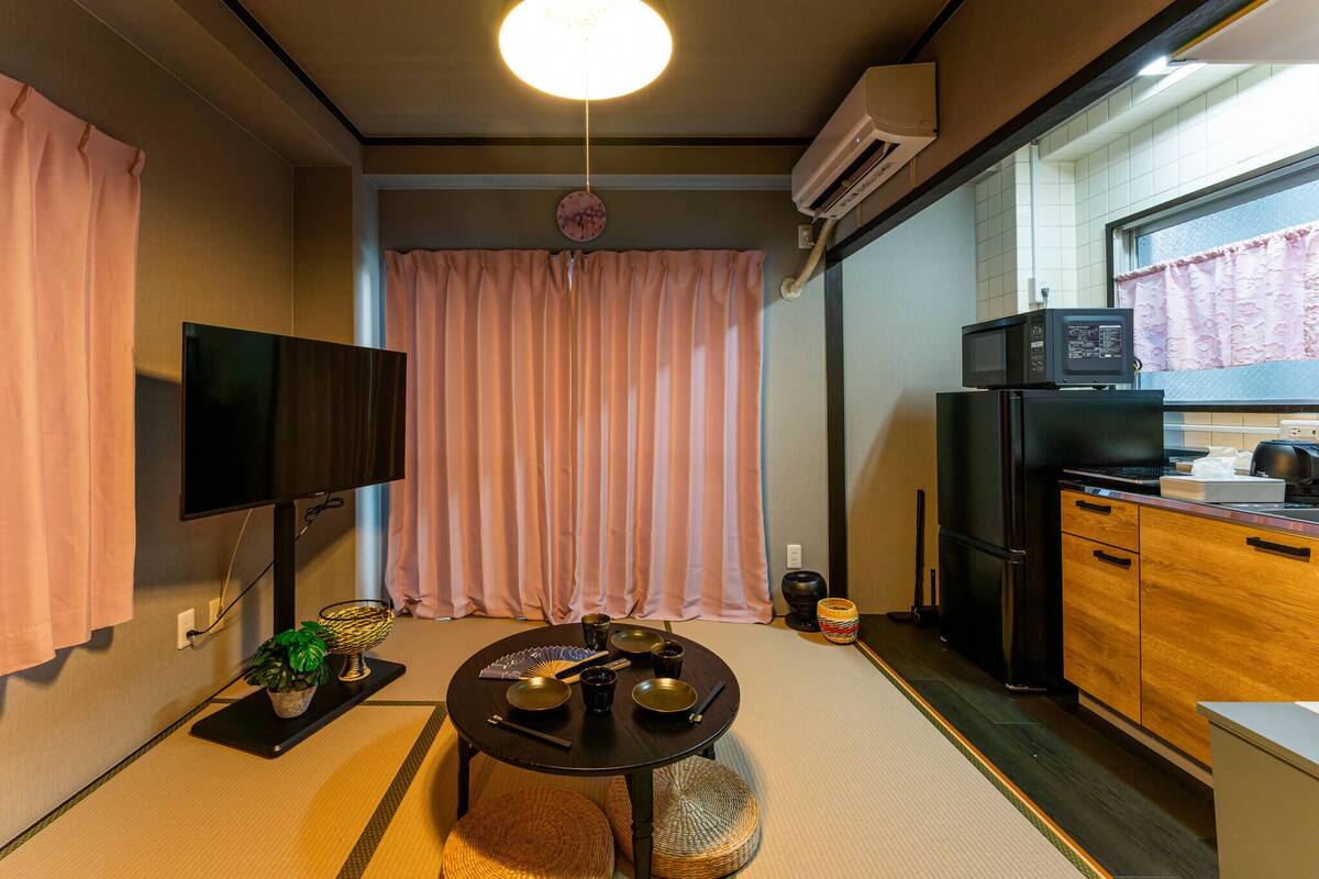 A compact kitchen with a TV, microwave, and refrigerator.