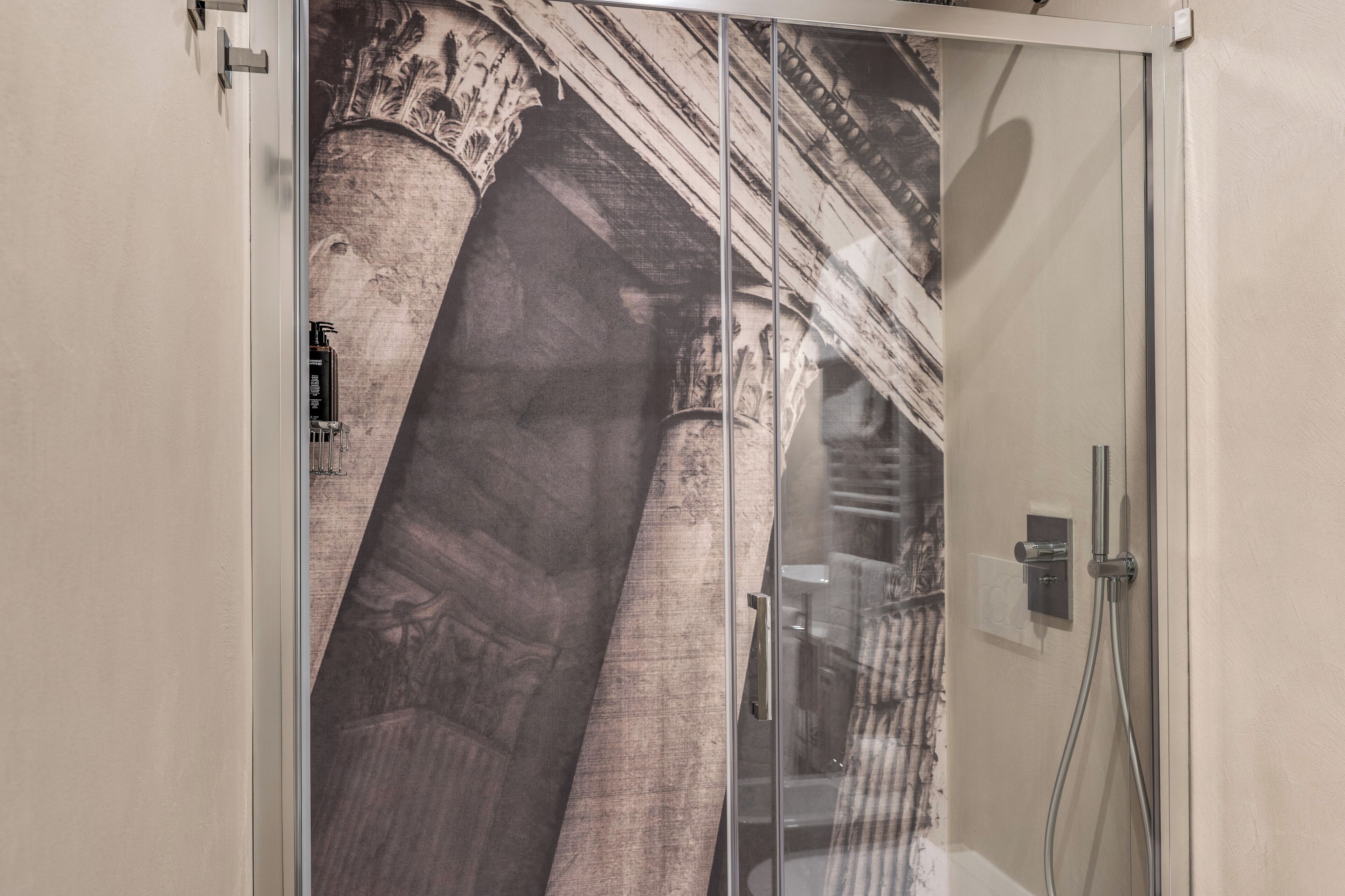 A bathroom with a glass shower enclosure, a towel rack, and a mirror.