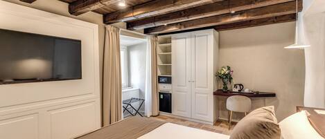 Une chambre à coucher comprenant un lit, un téléviseur fixé au mur, un bureau avec une chaise et une armoire.