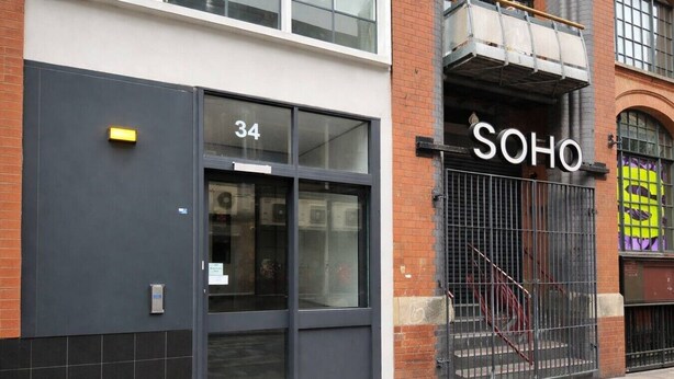 A building with a large glass door marked '34' and a metal gate with 'SOHO' written above it. - Apt 4,34 Wood street (Liverpool)