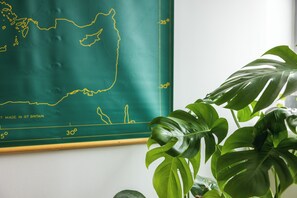 Un mapa en la pared, una planta y una viga de madera.