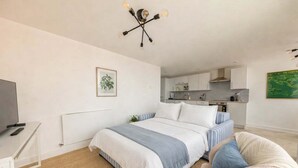 Een moderne slaapkamer met een bed, nachtkastje en een televisie.