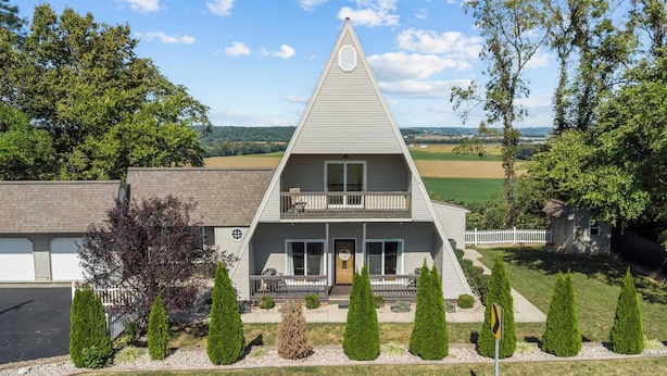 A two-story house with a triangular roof, a front porch, and a garage. - A-Frame Home | Ultimate Retreat in Bourbon Country (Coxs Creek)