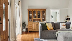 A living room with a grey sofa, wooden cabinet, and a potted plant. - A-Frame Home | Ultimate Retreat in Bourbon Country (Coxs Creek)