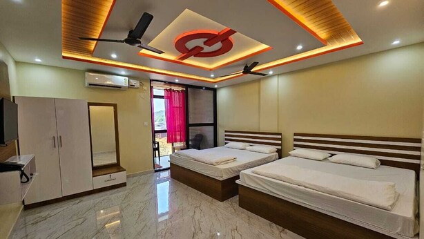 Un dormitorio moderno con dos camas, un armario y un plafón con una lámpara central.