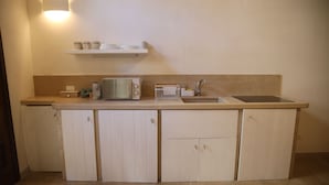 Eine kleine Küche mit Mikrowelle, Toaster und Spüle.