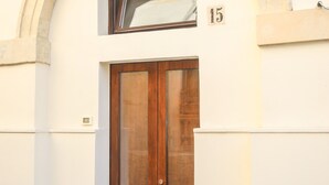 Ein zweistöckiges Gebäude mit einer großen Holztür und einem Fenster darüber.