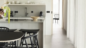 Una cocina moderna con una isla central, sillas negras e iluminación colgante.