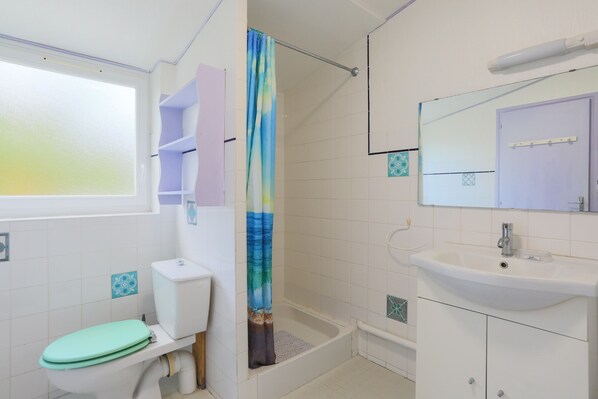 A bathroom with a toilet, shower, sink, and a window. - Holiday Home 'Yvonne' with Private Garden and Wi-Fi (Plouha)