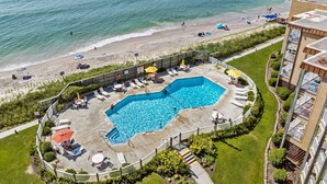 A pool area with a view of the beach and ocean, surrounded by a fence and lounge chairs. - Enjoy oceanfront views from this 2BR condo at Topsail Dunes 3308 in North Topsail Beach. (North Topsail Beach)
