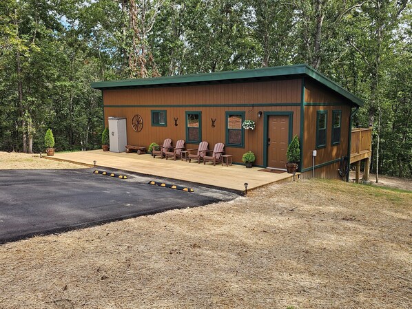 Una baita con rivestimento in legno, un portico con sedie e un terrazzo.