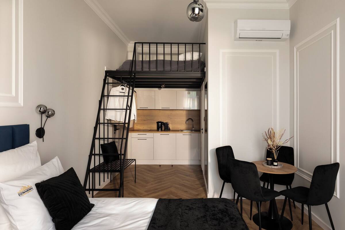 Un estudio pequeño con literas, kitchenette y un rincón de comedor.