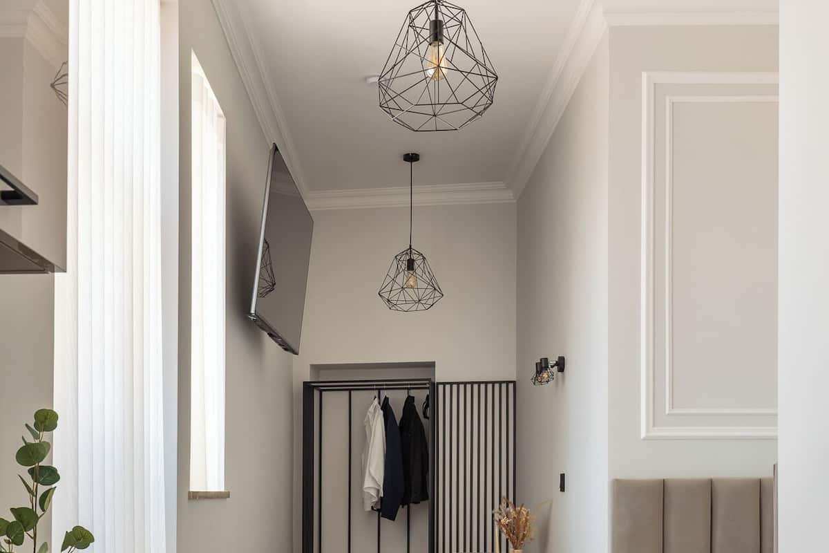 Un dormitorio moderno con cama, mesita de noche y lámpara colgante.