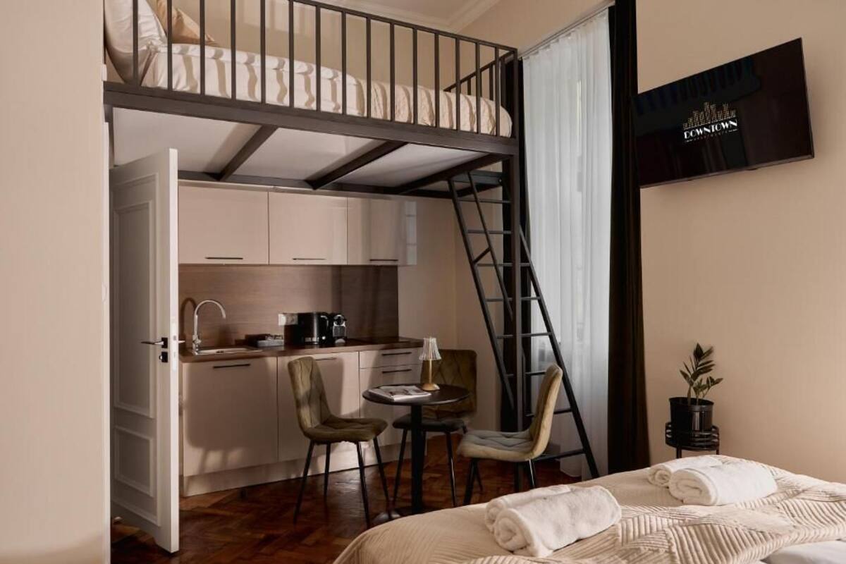 Habitación pequeña con literas, kitchenette y un rincón comedor.