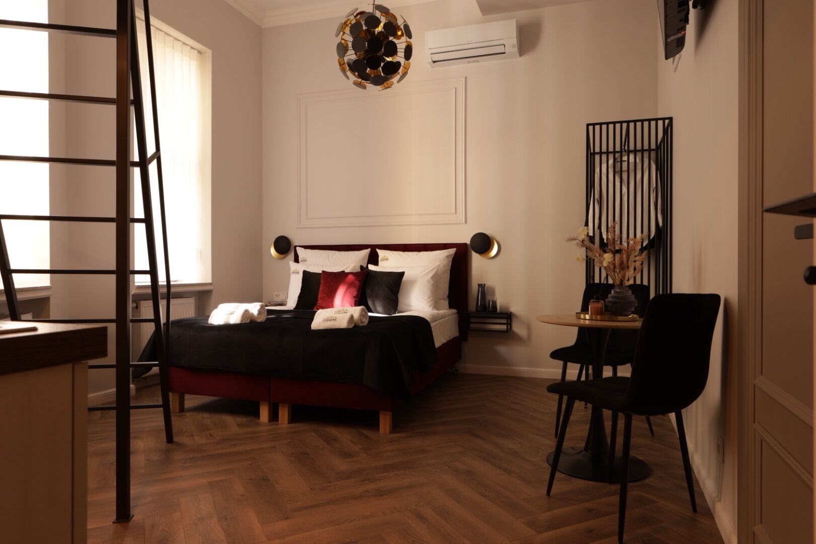 Une chambre d’hôtel comprenant un lit, un bureau, une chaise, une table et un élément décoratif mural.