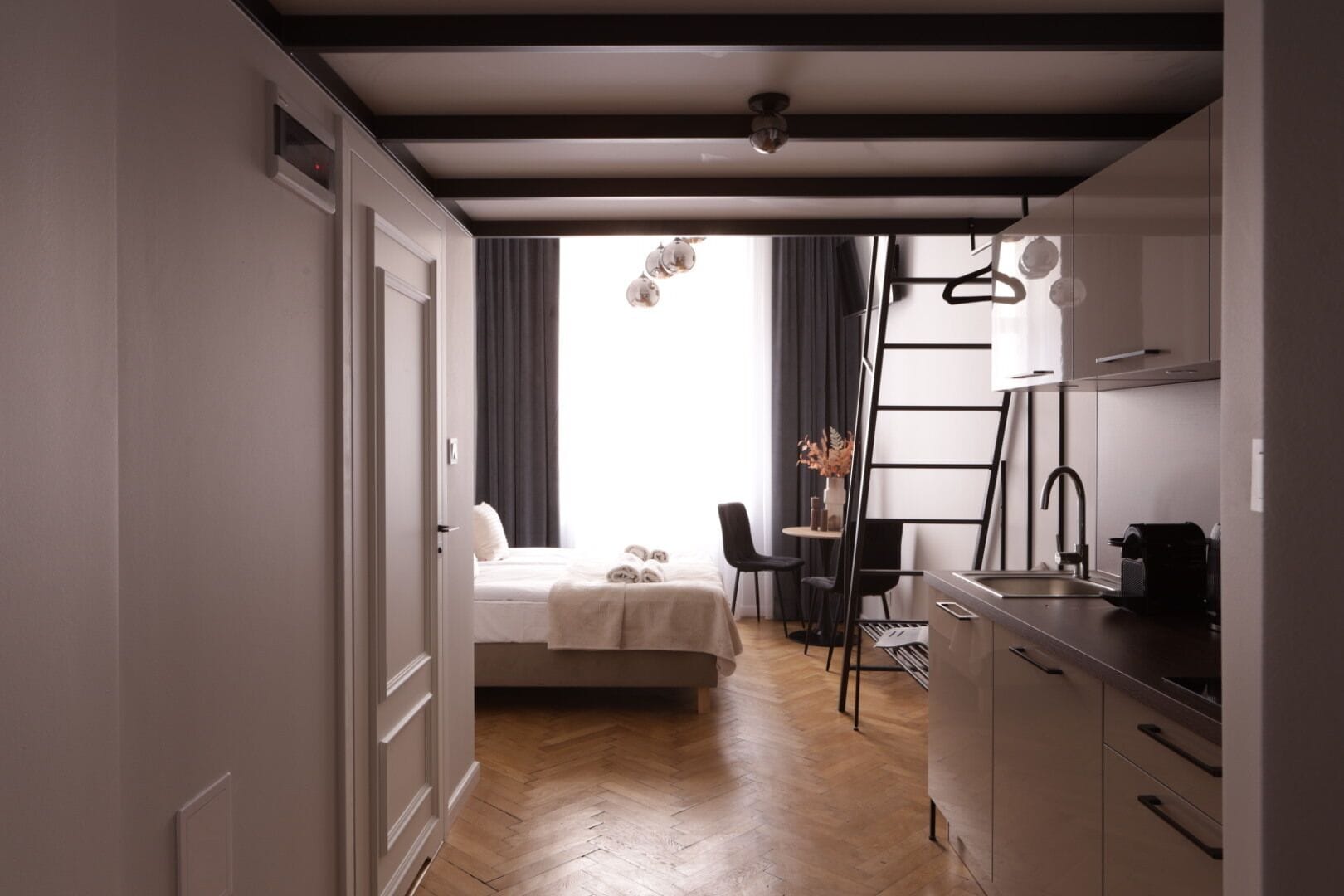Habitación de hotel pequeña con cama, un escritorio y un rincón americano.