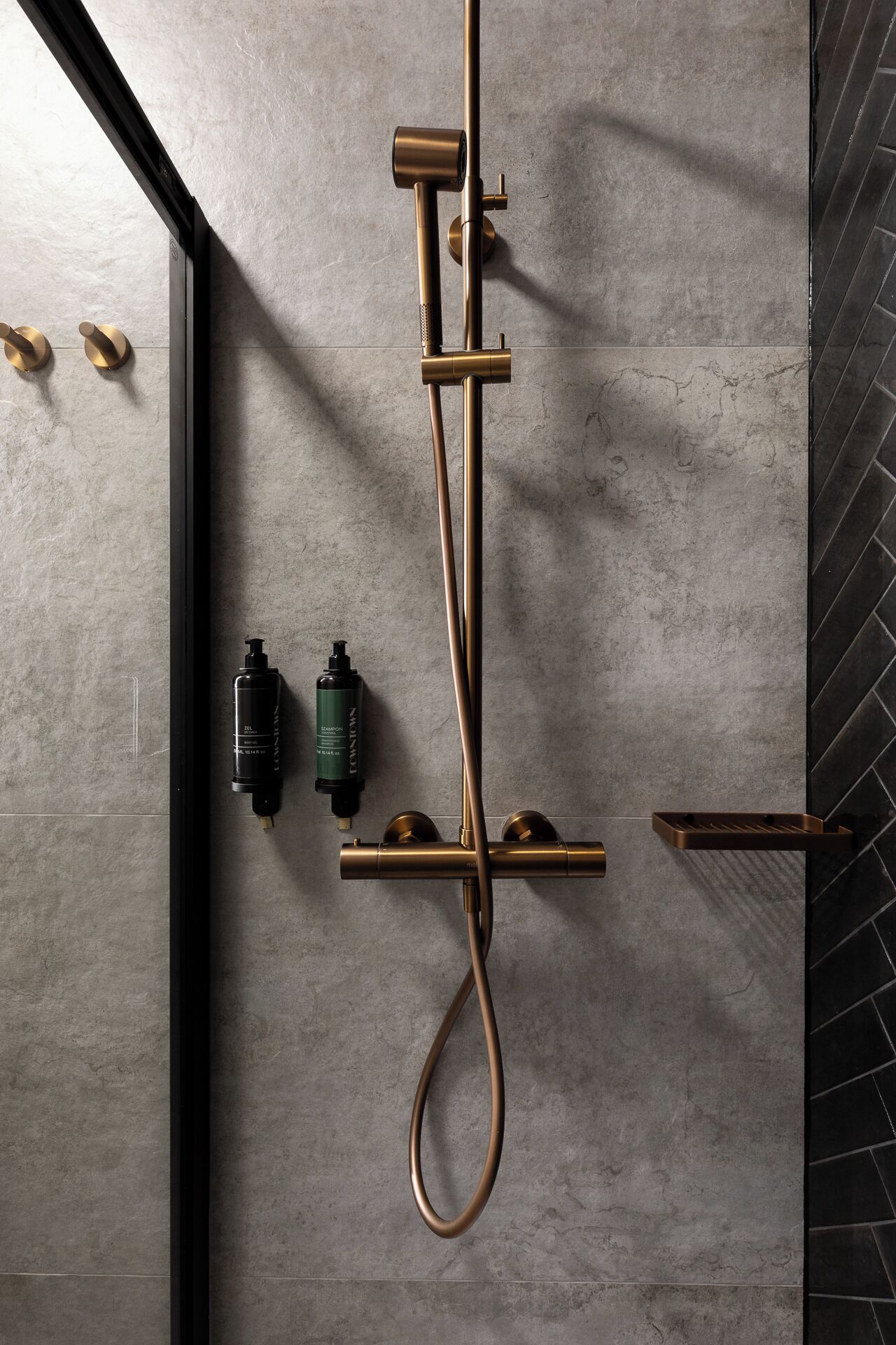 Une douche moderne dotée d’un flexible incurvé et d’un panneau de commande fixé sur un mur à texture.