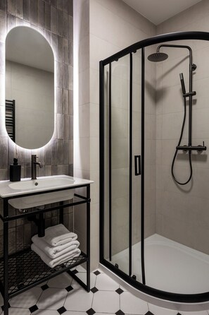 Suite estudio Deluxe | Baño | Ducha, artículos de higiene personal gratuitos y secador de pelo