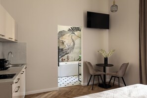 Deluxe studio suite, bad | Woonruimte | Een 35-inch flatscreentelevisie met kabelzenders
