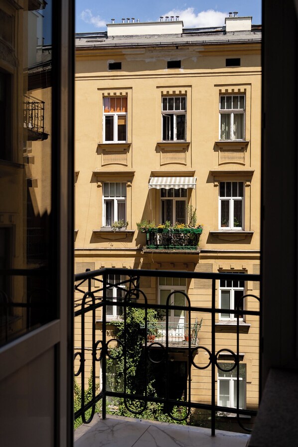 Ein Gebäude mit vielen Fenstern und Balkonen, von denen einige mit Pflanzen bepflanzt sind.